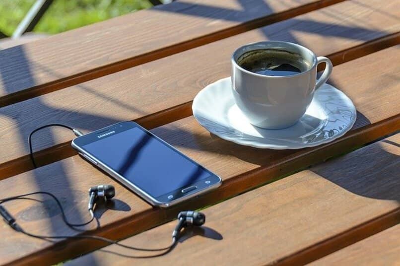 samsung galaxy s4 on a bench next to a cup of coffee