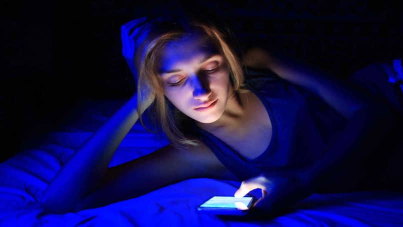 woman uses phone and shows blue light