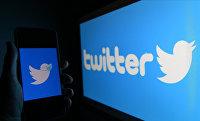 Twitter social network logo on mobile phone and computer screens