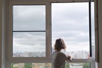 A girl looks out the window in one of the apartments in a multi-storey residential building on 10 A Avangardnaya Street in Moscow, intended for the resettlement of participants in the renovation program.